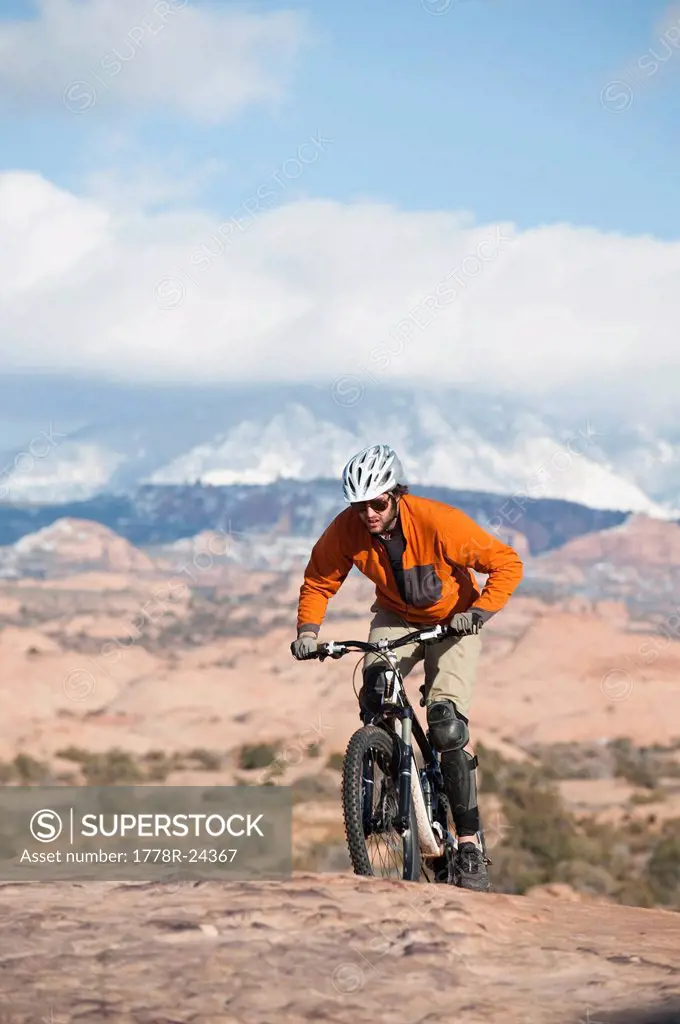 A young man rides his mountain bike on the Slickrock Trail, Moab, UT.