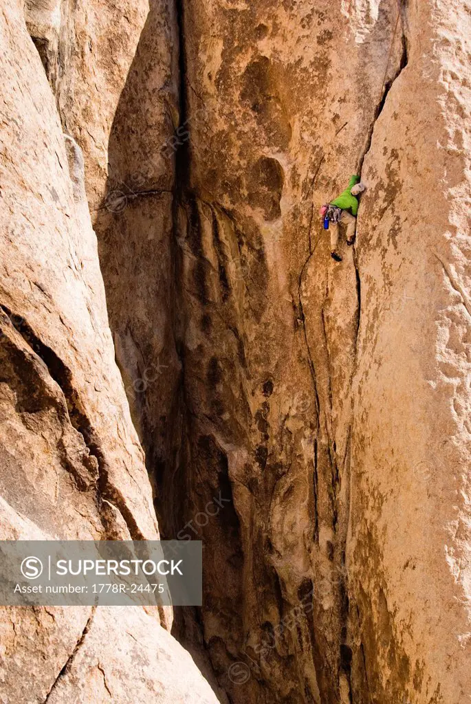 A young man climbing a long crack.