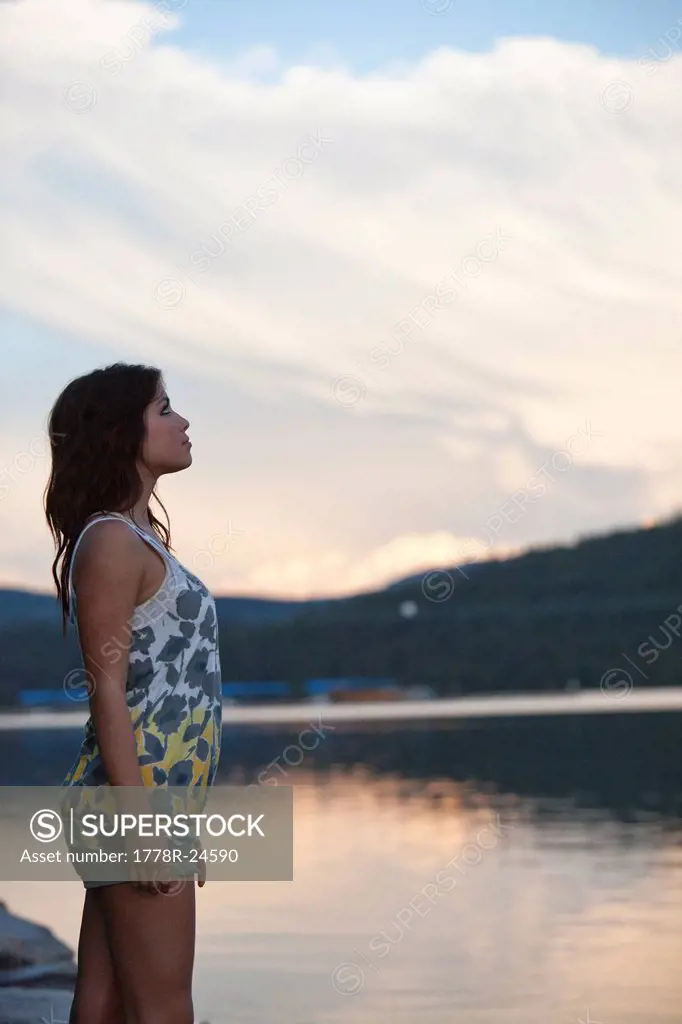 Young woman watches the sunset over the lake in Idaho.