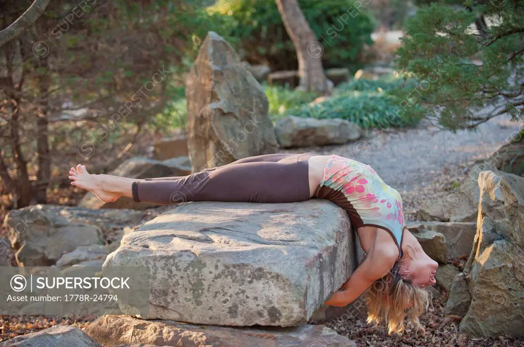 A woman doing yoga postures in outdoor setting.