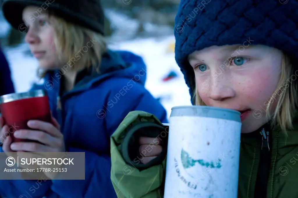 Two brothers enjoy hot chocolate in the California backcountry.