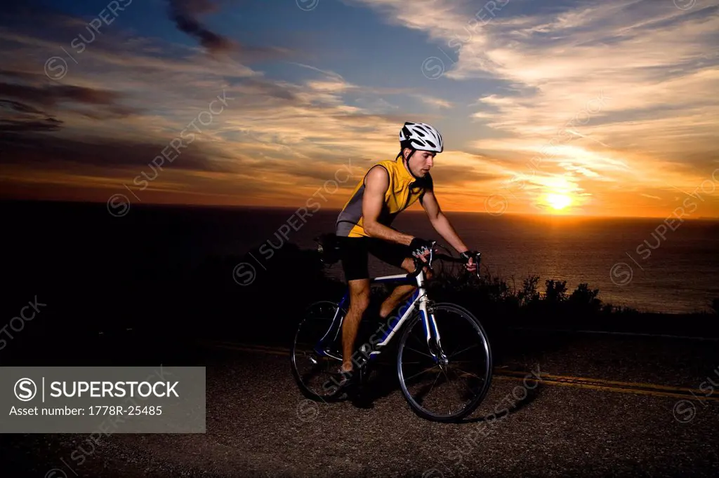 A cyclist in a yellow tank top rides his bike up Deer Creek road in Malibu, California.