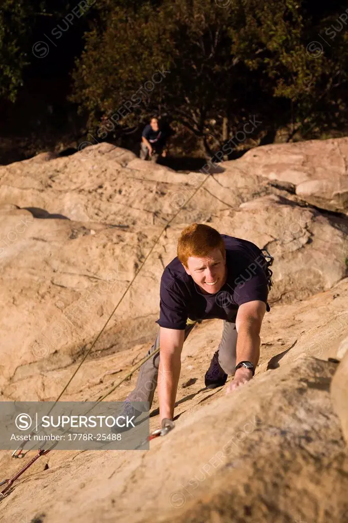 A young male climber works his way the 5.9 crack at Piuma Pinnacle in Malibu, California.