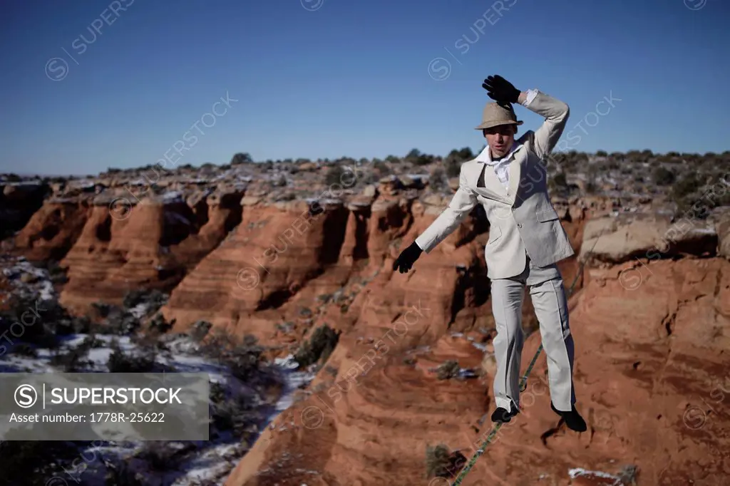 Male highliner in white pinned stripe suite, Moab, Utah, USA.