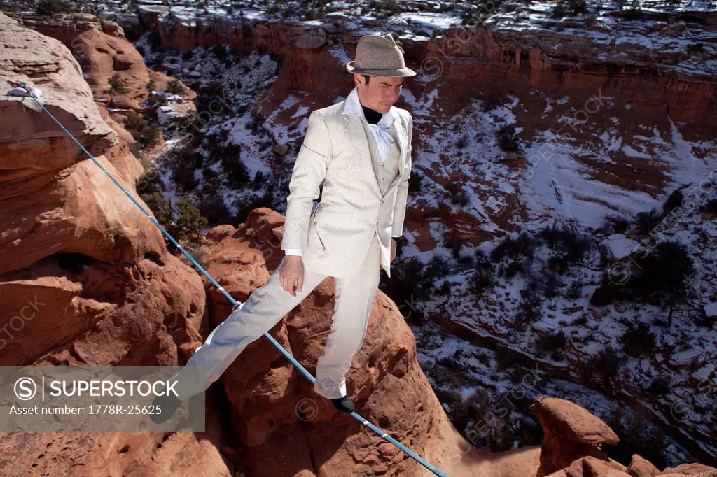 Male highliner in white pinned stripe suite, Moab, Utah, USA.