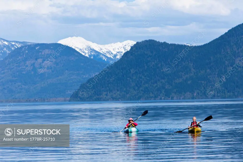 An happy adventurous retired couple kayaking on a huge calm lake in Idaho.