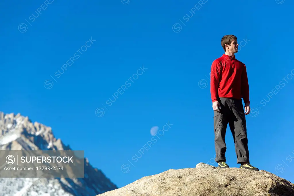 Man standing on top of a boulder.
