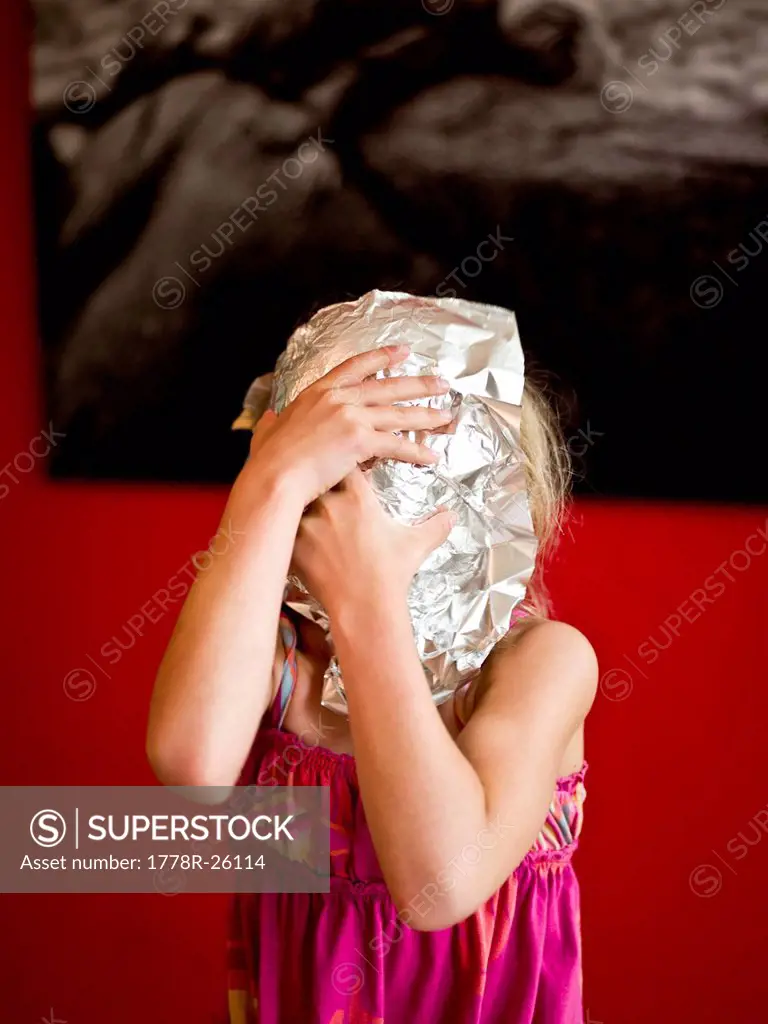 girl makes a mask with tin foil