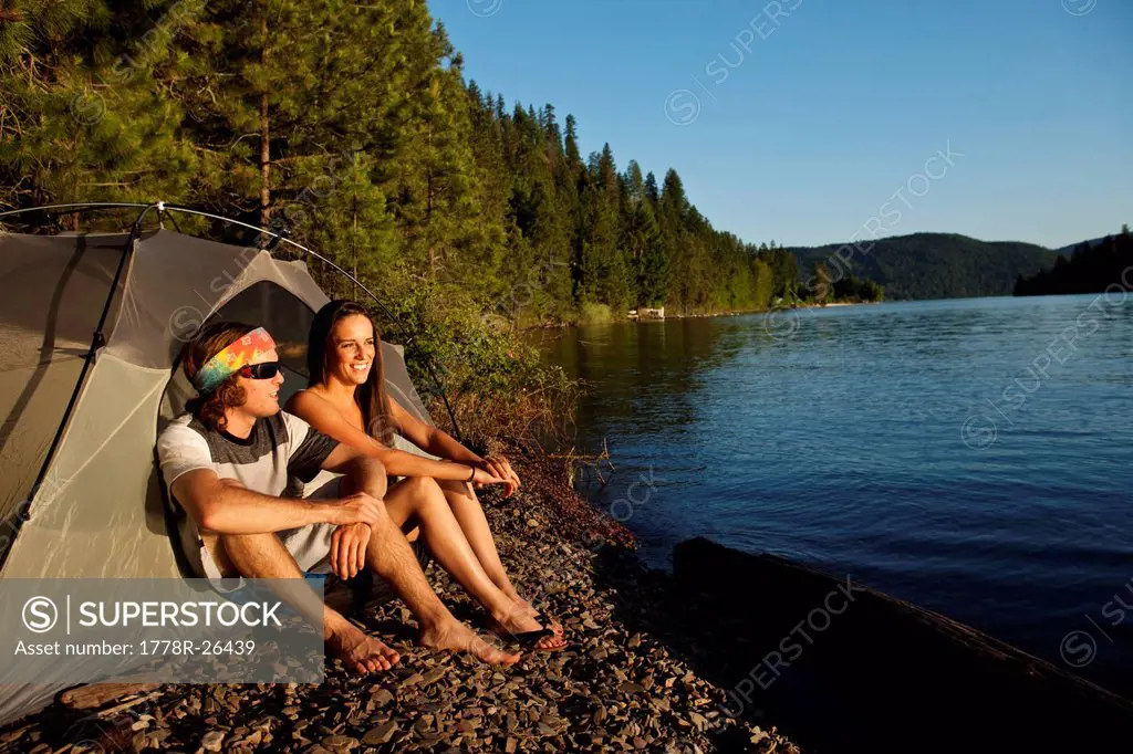 Two young adults laugh and smile on a camping and kayaking trip in Idaho.