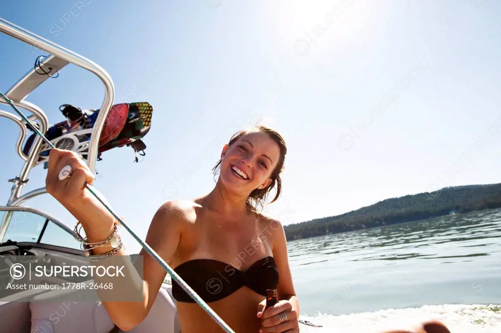 A young woman smiling on a wakeboard boat in Idaho.