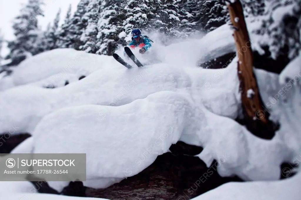 A male skier blasts through powder pillows in the backcountry in Colorado.