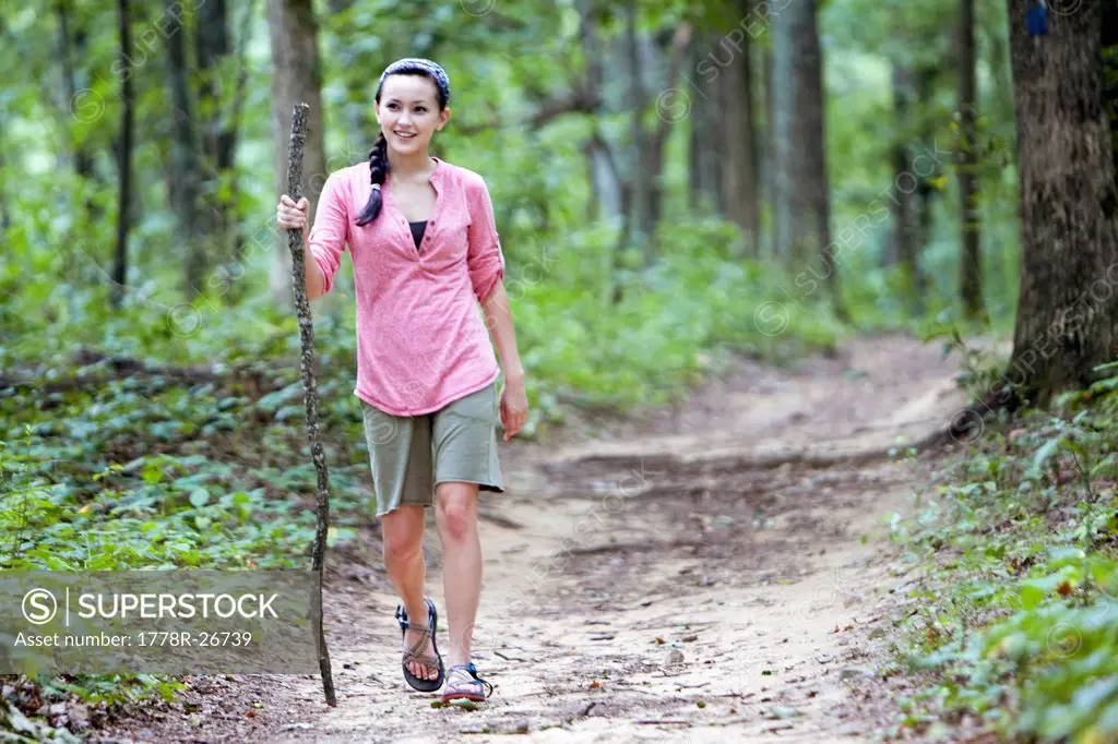 A girl hikes through through woods.
