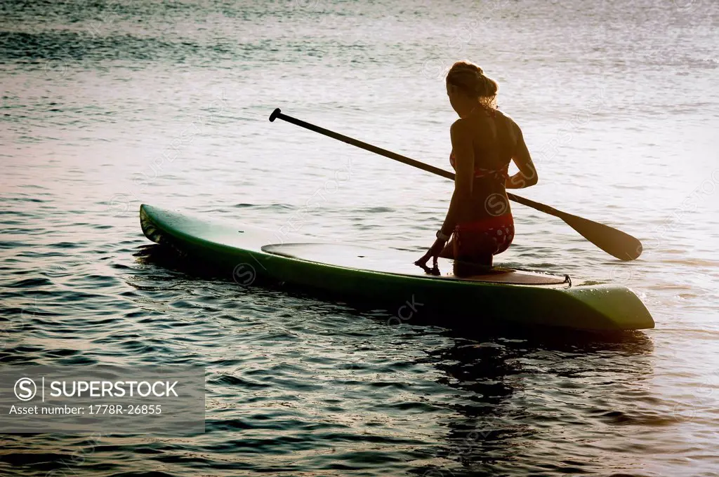 A woman enjoys her stand up paddle board.
