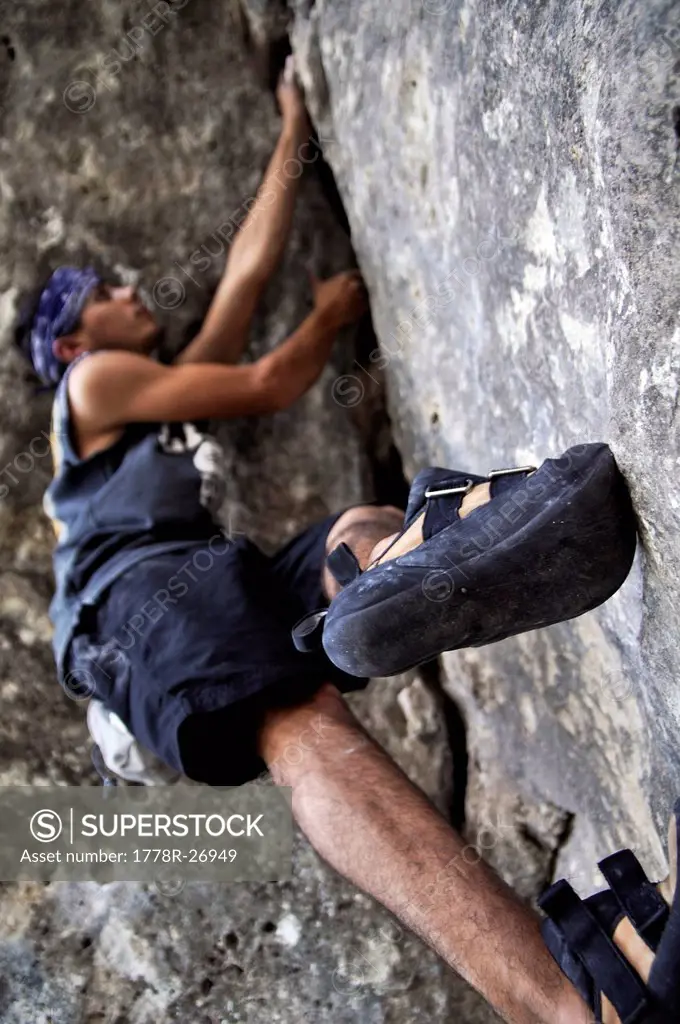 A rock climber navigates a bouldering problem.