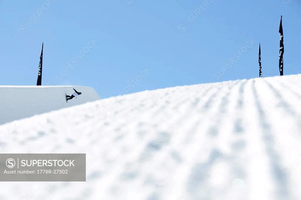 A snowboarder on a half pipe.
