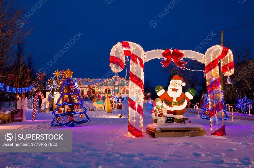 Santa Claus and other holiday decorations and lights in the snow in North Rustico, Prince Edward Island, Canada.