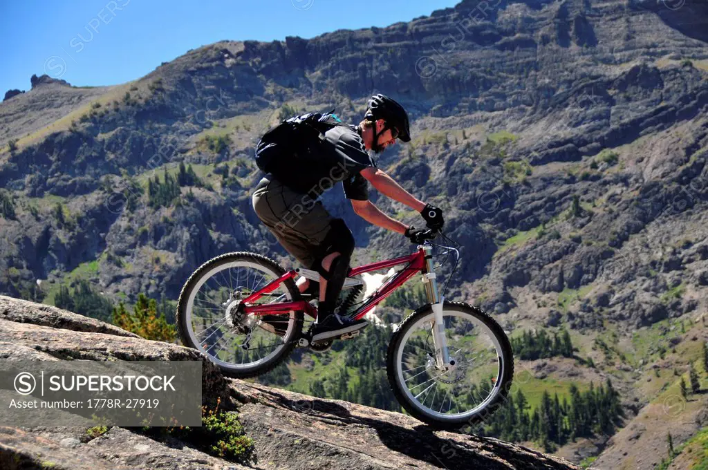 A mountain biker rides down a technical section of rock at Kirkwood Mountain Resort in the summer, CA.