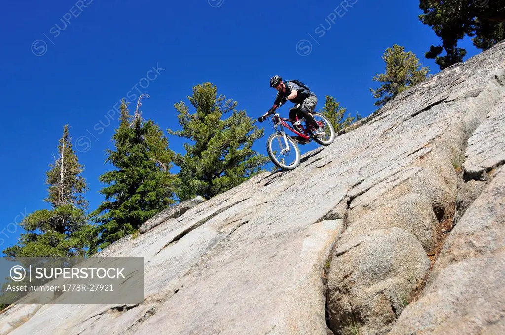 A mountain biker rides down an extremely steep slab of granite at Kirkwood Mountain Resort, CA.