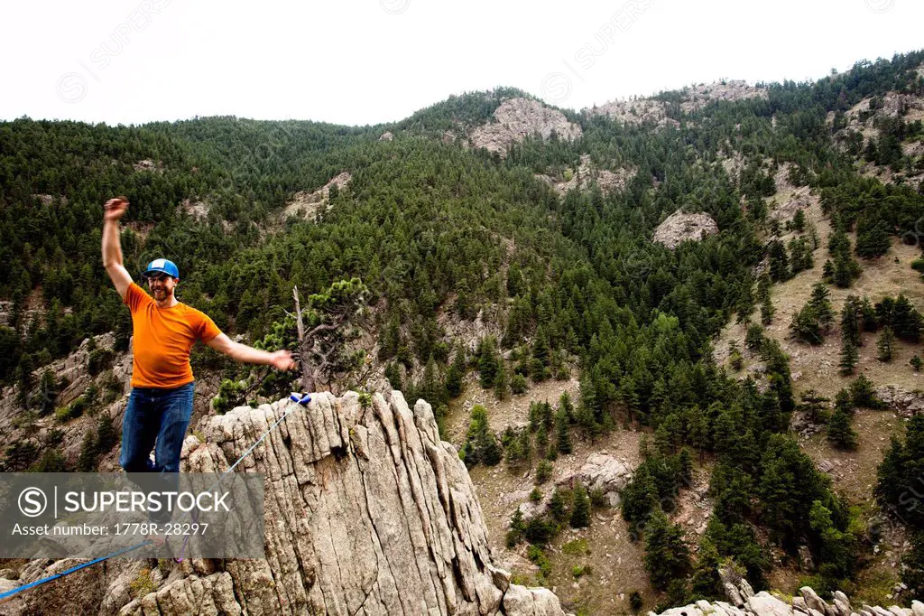 A male highliner walks the Elephant Buttresses highline in Boulder Canyon, Colorado.