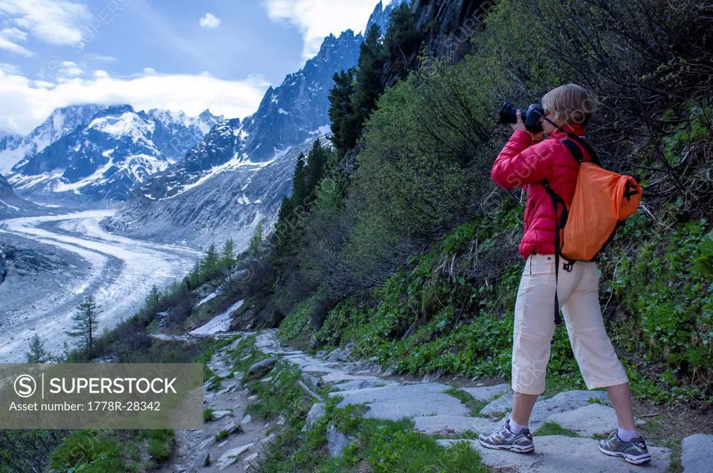 A female photographer as seen on sunny afternoon on a trail above Mer de Glace in Chamonix, France on June 1 2012.