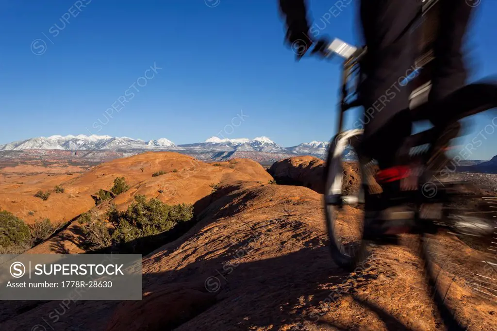 Mountain biker rides by in a blur on a rock trail.