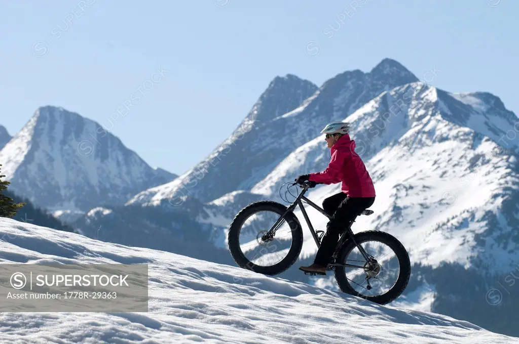 A woman riding a bike on the snow on Molas Pass, San Juan National Forest, Silverton, Colorado.