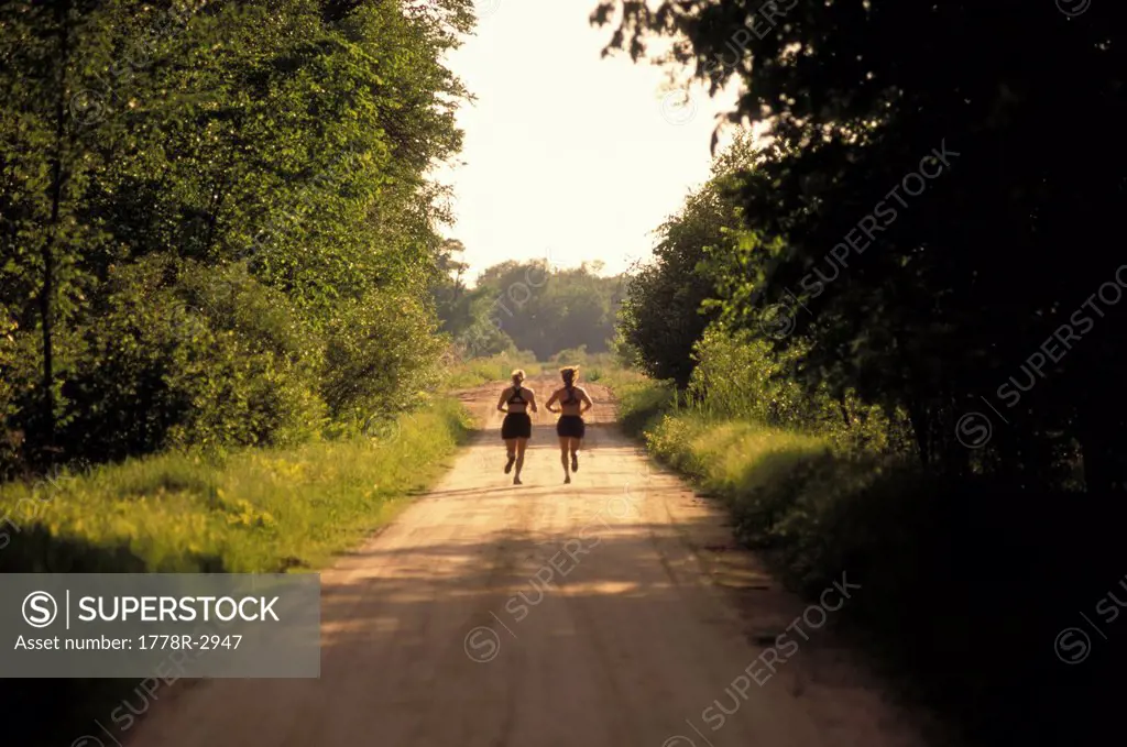 Runners on dirt road jogging.