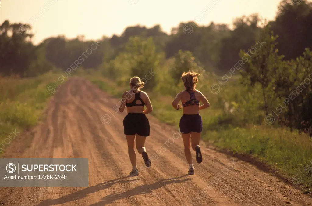 Runners on dirt road jogging.