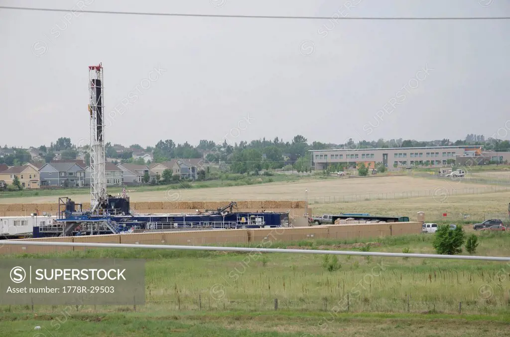 Drill rig working to drill a natural gas well to be fracked next to an elementary school.