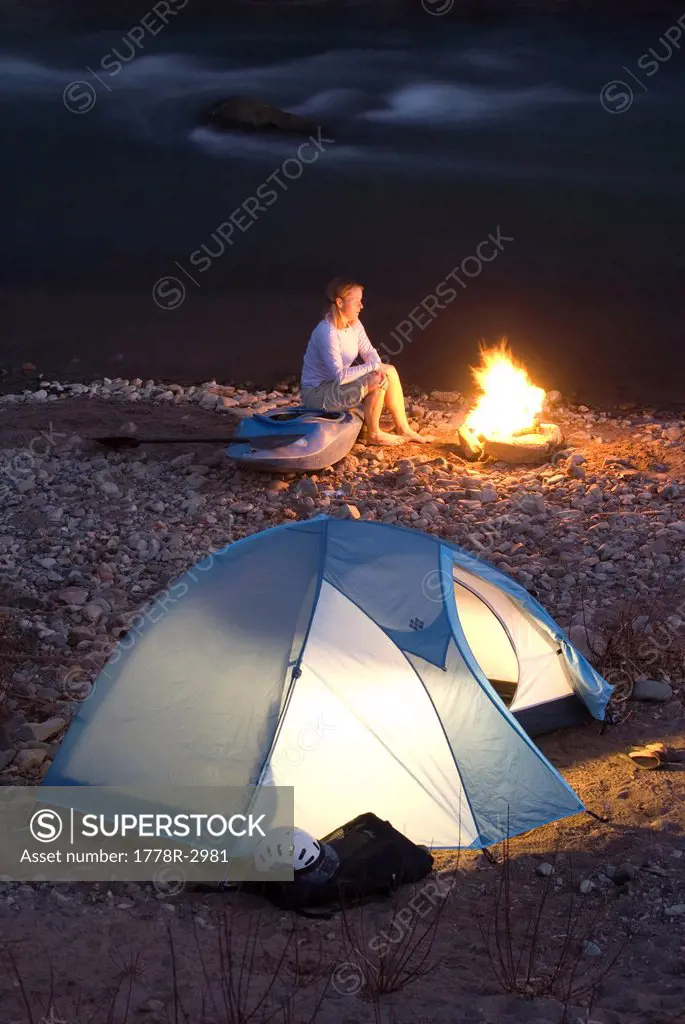 Camp fire and tent by the river.