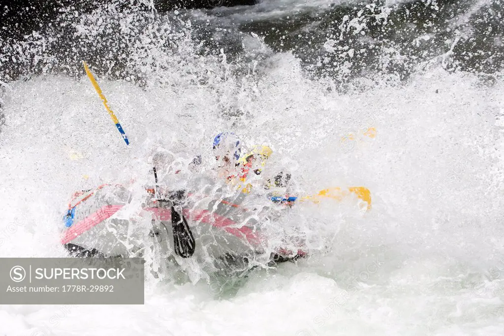 A group of people splash through white water rapids while rafting the Strands River near Voss, Norway.