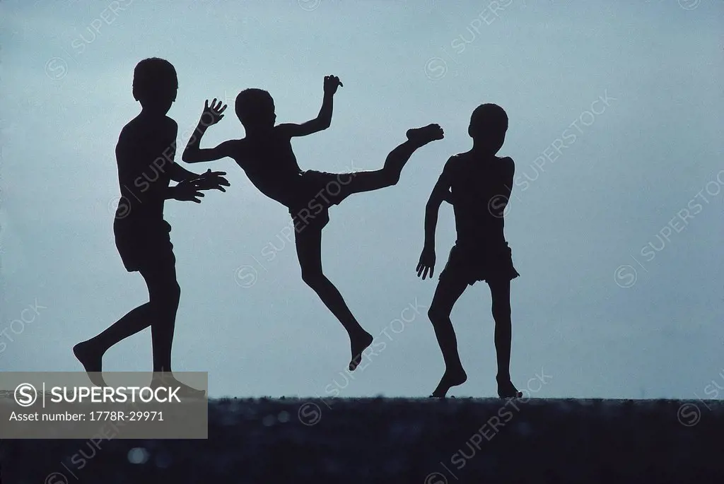 Silhouette of boys playing, Brazil.