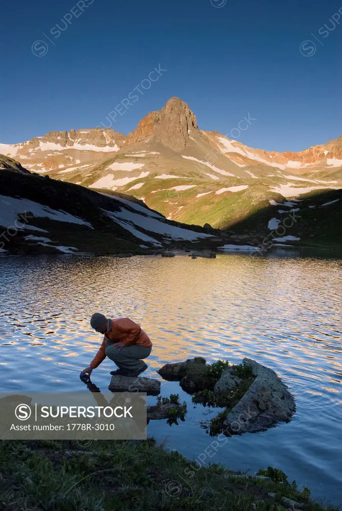 Man fills a water bottle in Ice Lake.