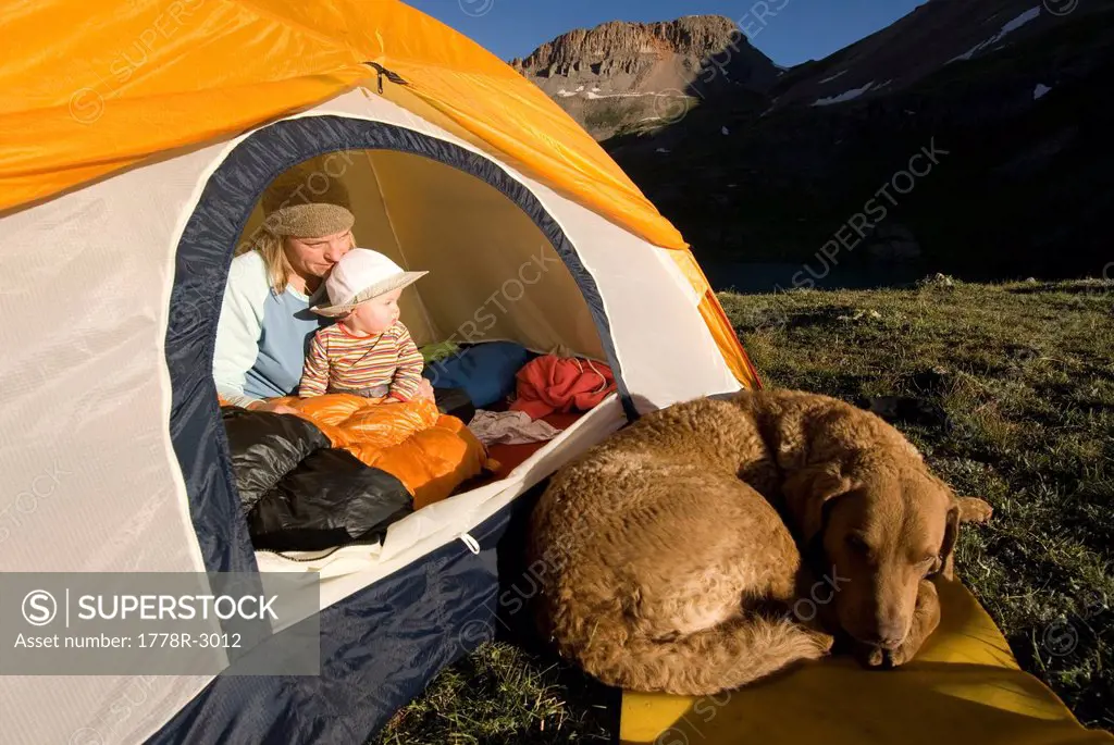 Mother, child and dog at a tent.