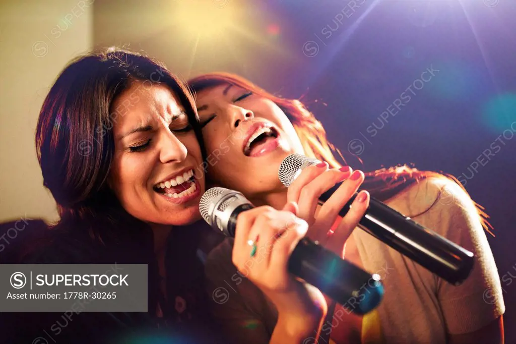 Two women singing karaoke.