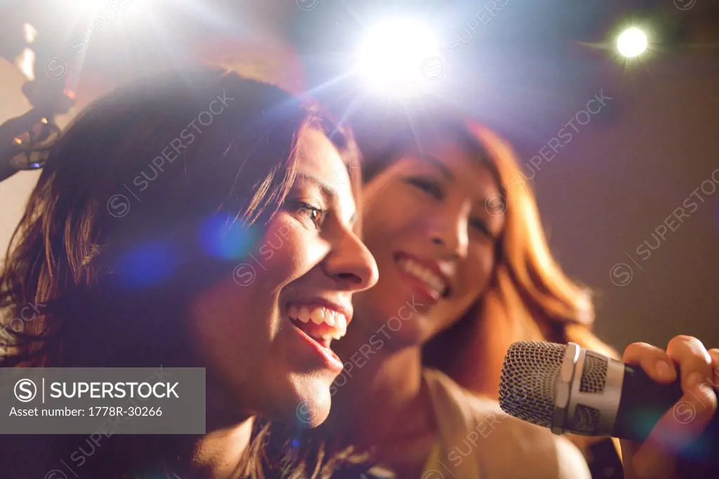 Two women singing karaoke.