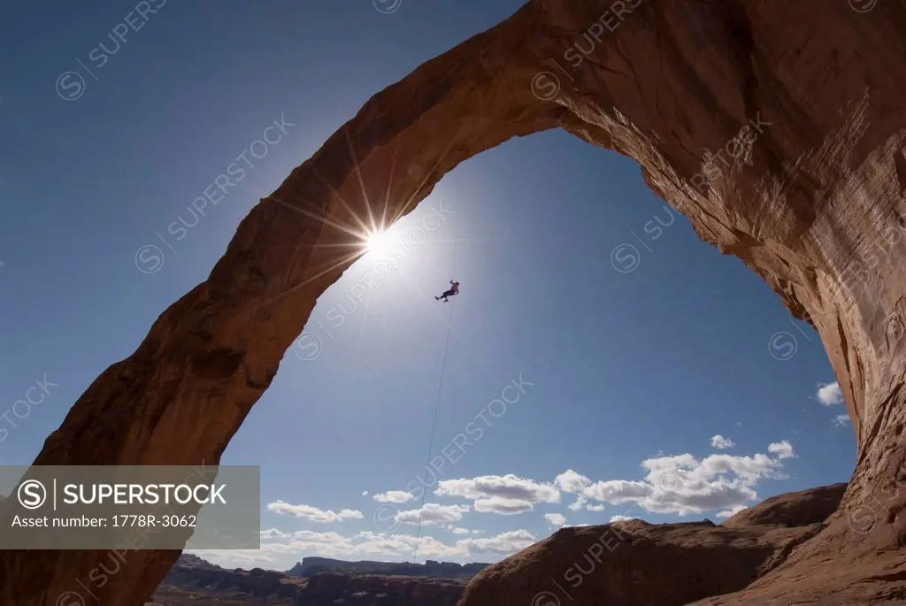 Man rappels off arch in Moab.