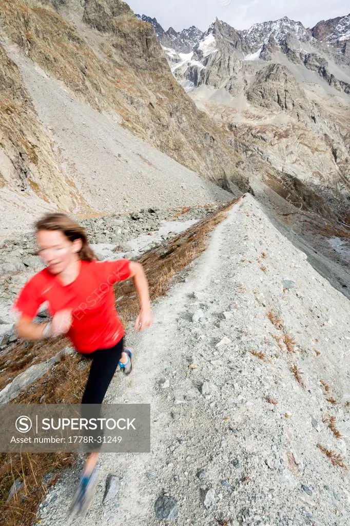 Woman trail running above the Glacier Noir.