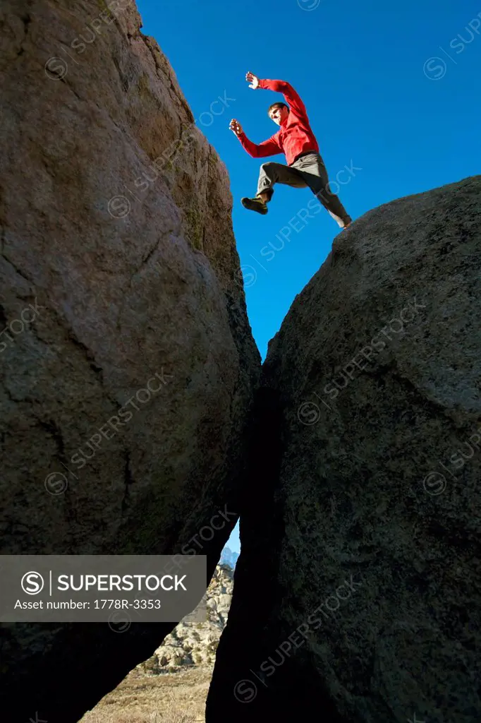 Man jumping across boulders.