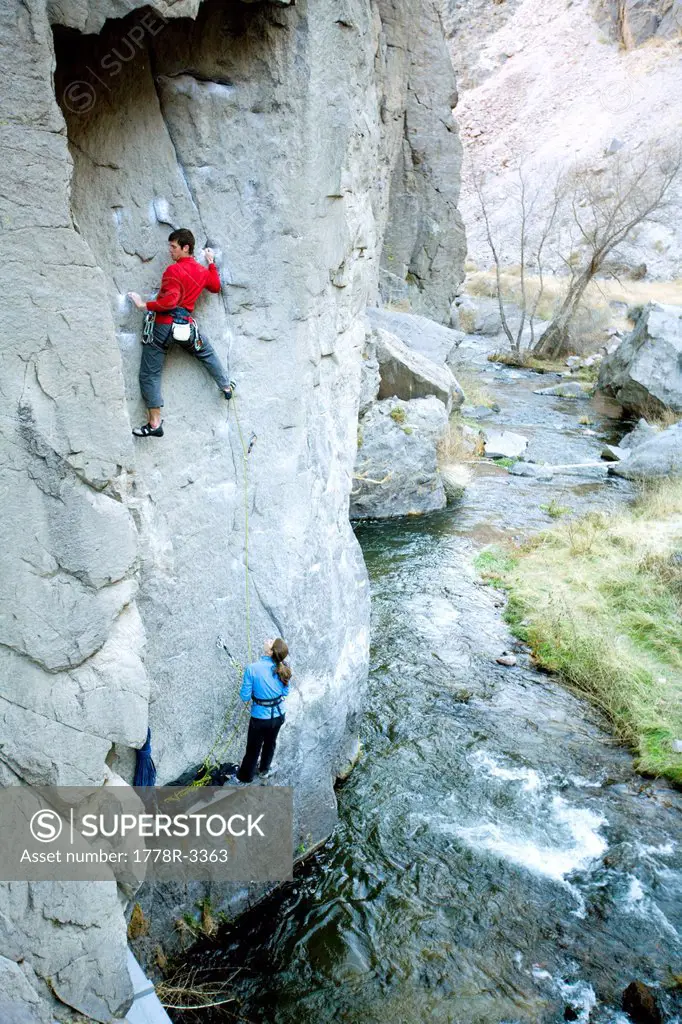 Two climbers above river.