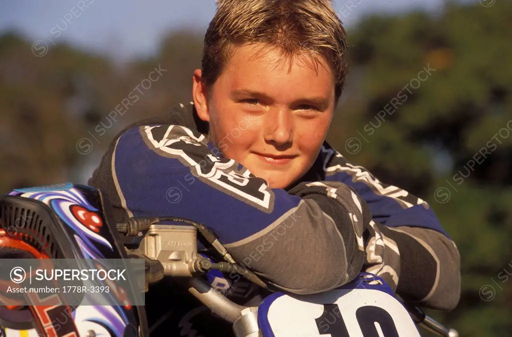 Young motor_cross racer with his bike.