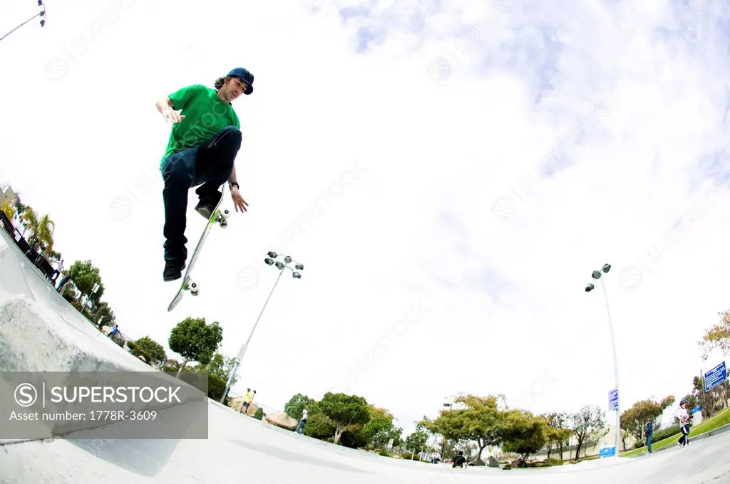 A skateboarder does a trick at the skate park.