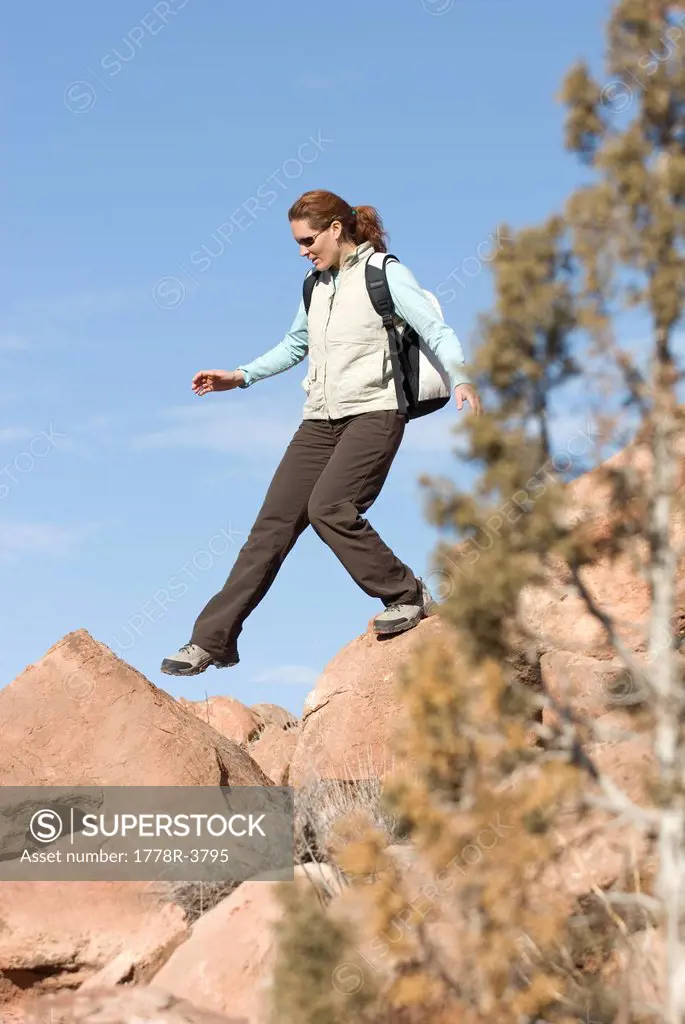Woman stepping between rocks.
