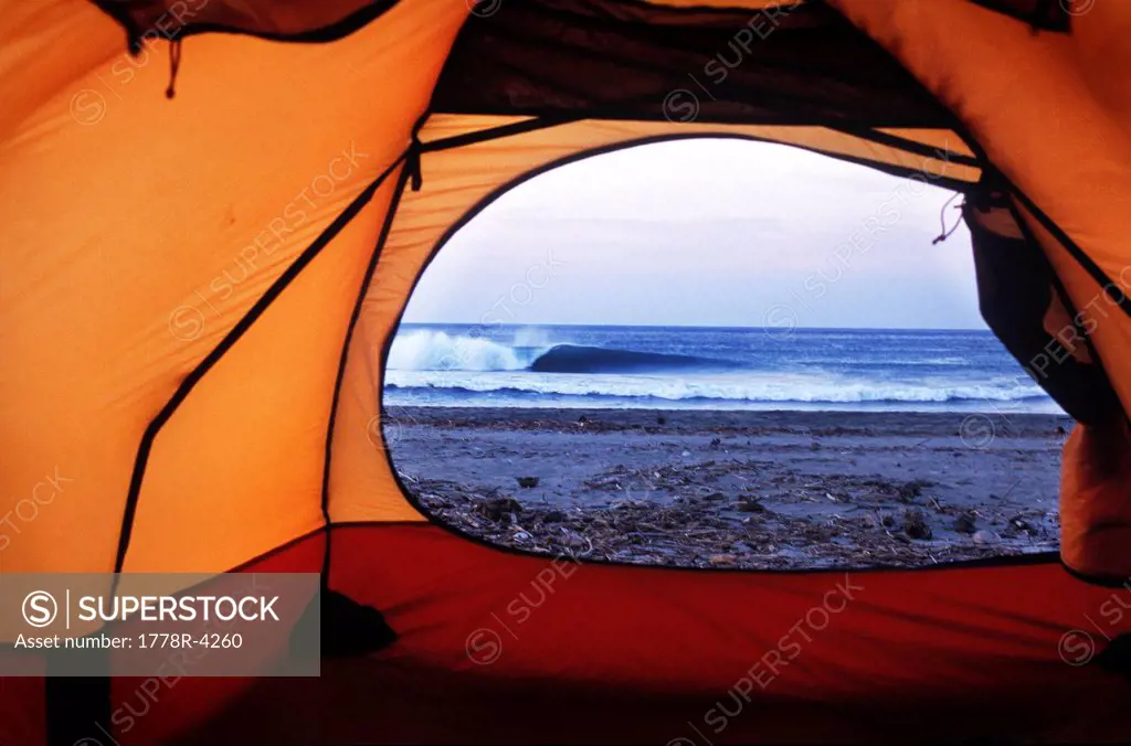 A view from inside a tent looking at a breaking wave in Michoacan, Mexico.