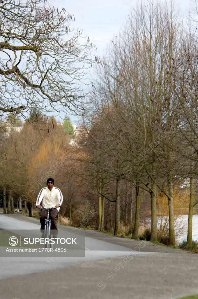 A young man rides a bike on a bike path.