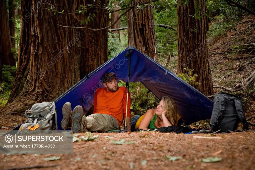 A young couple camping in the redwood forests of Big Sur.