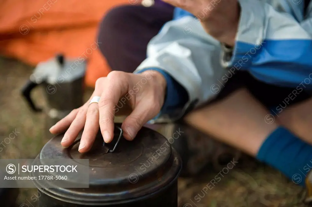 Detail of a young woman´s hand while making coffee during a camping trip in Grand Teton National Park, Wyoming.