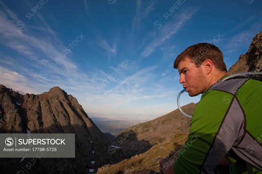 A man taking a water break on a ridge in the Sangre de Cristos Mountains, Colorado.