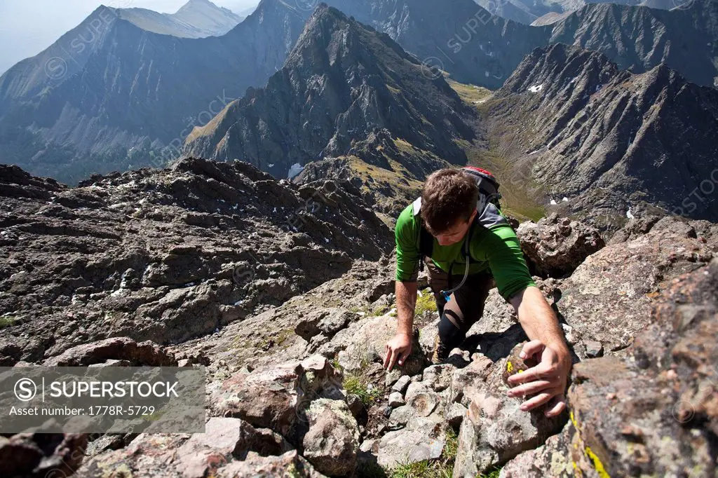 A man scrambles up a gully on the Crestone Needle in the Sangre de Cristo Mountains, Colorado.