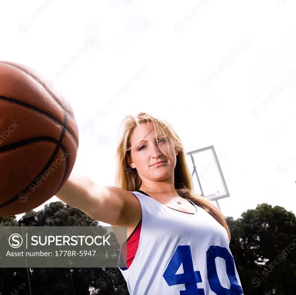 An athletic woman plays basketball.
